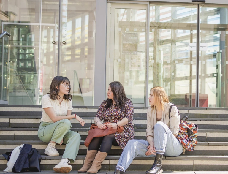 Students sat on steps outside of their university campus