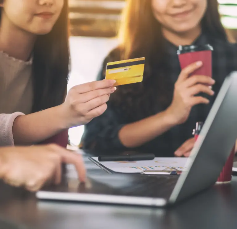 Person holding card up in front of laptop