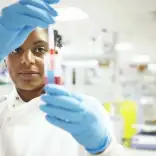 Student measuring liquid in test tube in high-tech lab